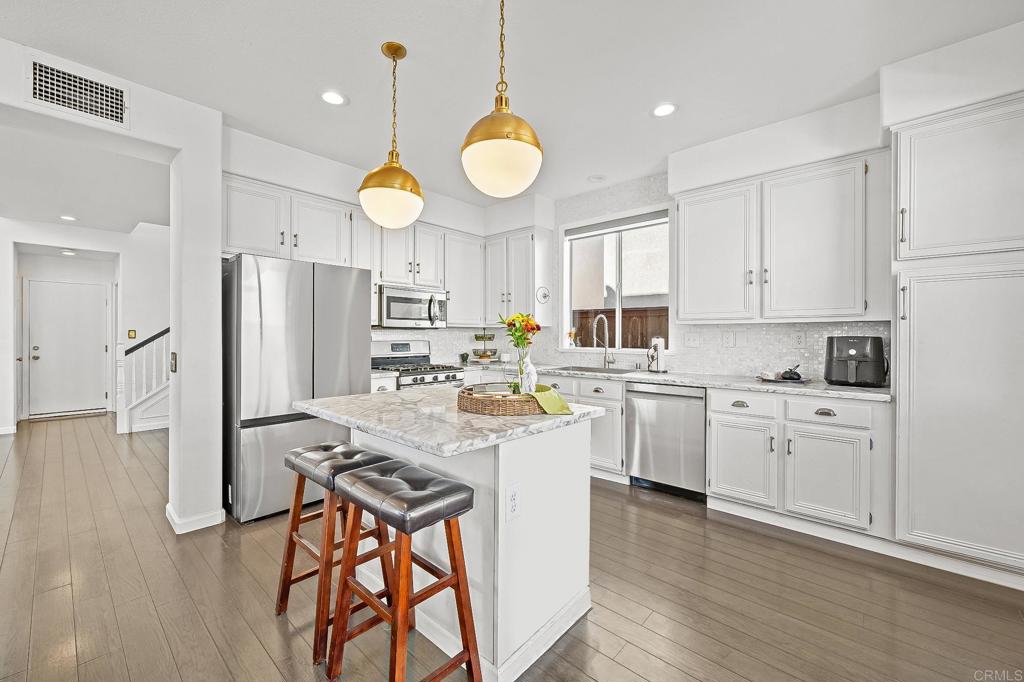 120 Venetia Way Oceanside, CA 92057 - Photo 3 of 32 a kitchen with white cabinets and stainless steel appliances