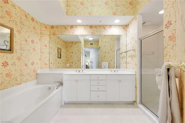 a bathroom with a double vanity sink a mirror and a bathtub