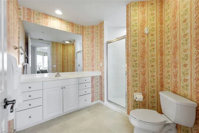 a spacious bathroom with a double vanity sink toilet mirror and shower
