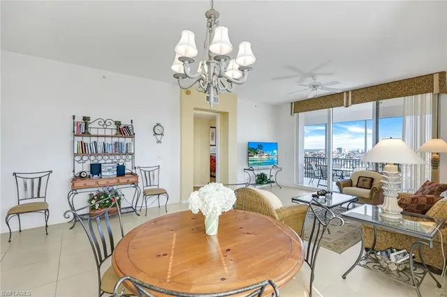 a living room with dining table and a chandelier
