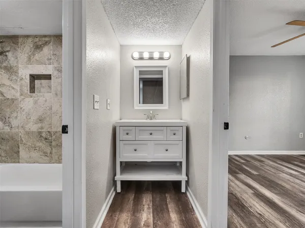 a bathroom with a tub sink and mirror