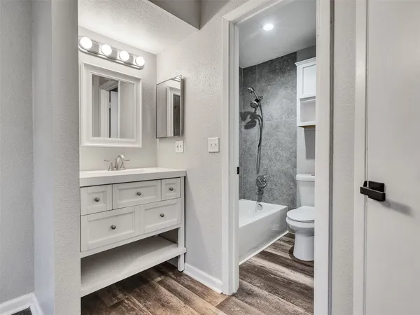 a bathroom with a double vanity sink a toilet a mirror and shower