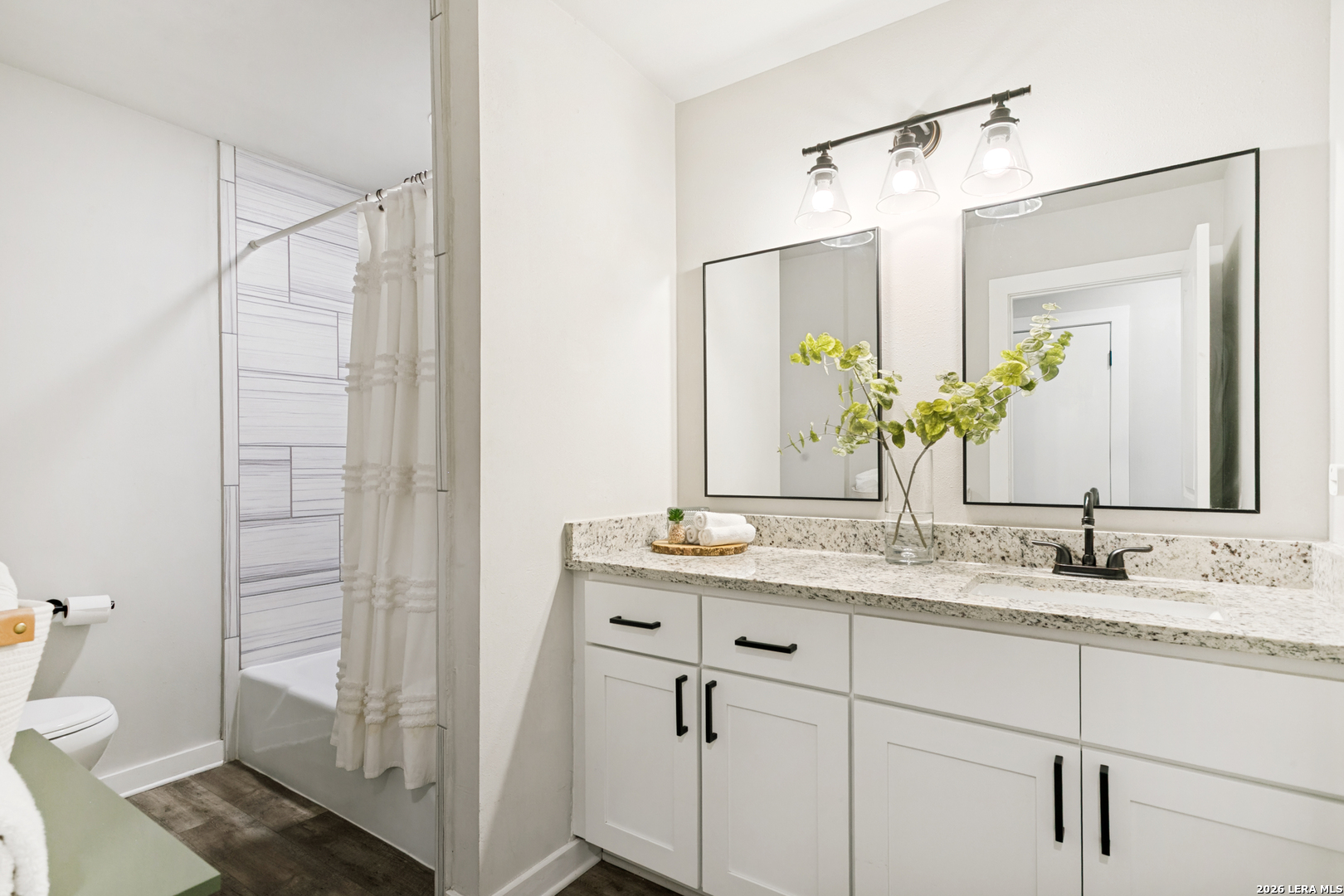 102 Silver Spring Universal City, TX 78148 - Photo 23 of 36 a bathroom with a granite countertop sink a toilet and a mirror