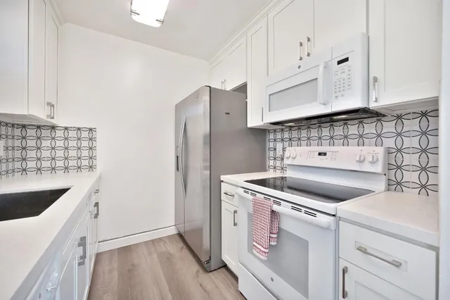 a kitchen with granite countertop a sink stove and refrigerator