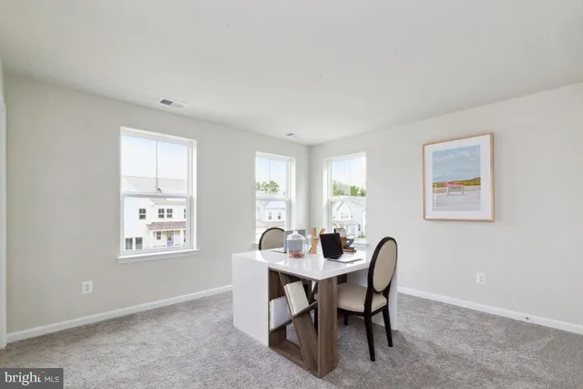 a view of a dining room with a table and chairs