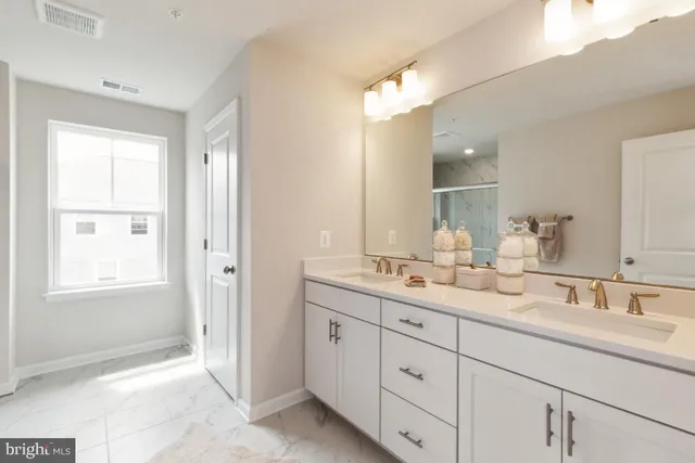 a bathroom with double sink and a mirror