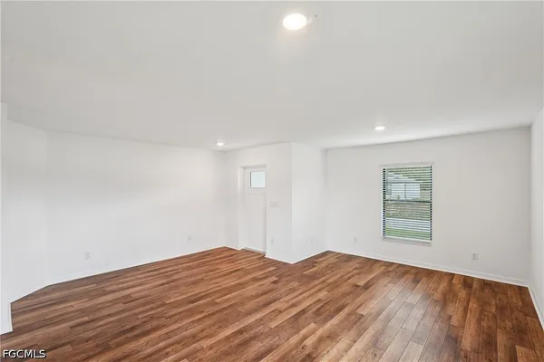 a view of a kitchen with a sink and dishwasher with wooden floor