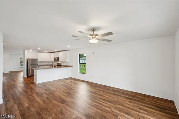 a kitchen with granite countertop stainless steel appliances a refrigerator a sink a stove a microwave and cabinets