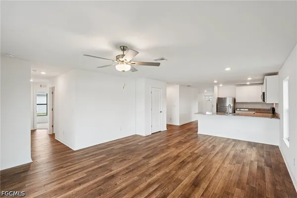 a kitchen with stainless steel appliances granite countertop a stove a sink a refrigerator a microwave a refrigerator and cabinets