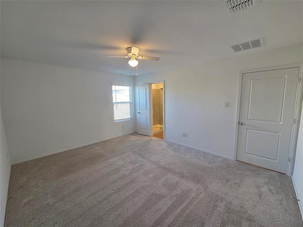 Spacious room with plush carpet, a ceiling fan, and a window with blinds