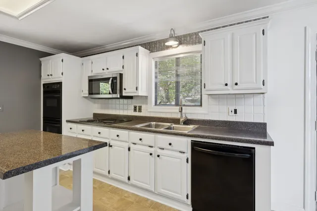 a kitchen with stainless steel appliances granite countertop a sink a stove and cabinets