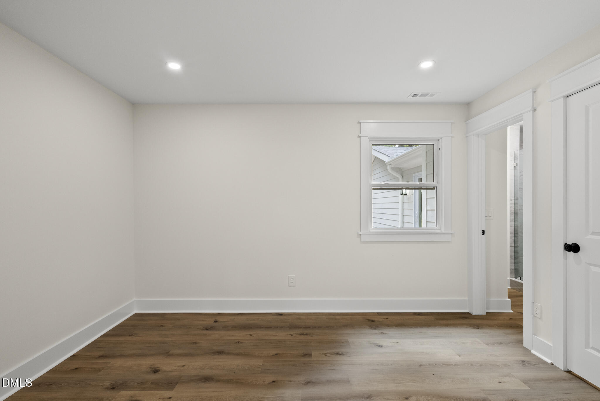 7804 Brandyapple Drive Raleigh, NC 27615 - Photo 25 of 58 a view of an empty room with wooden floor and a window