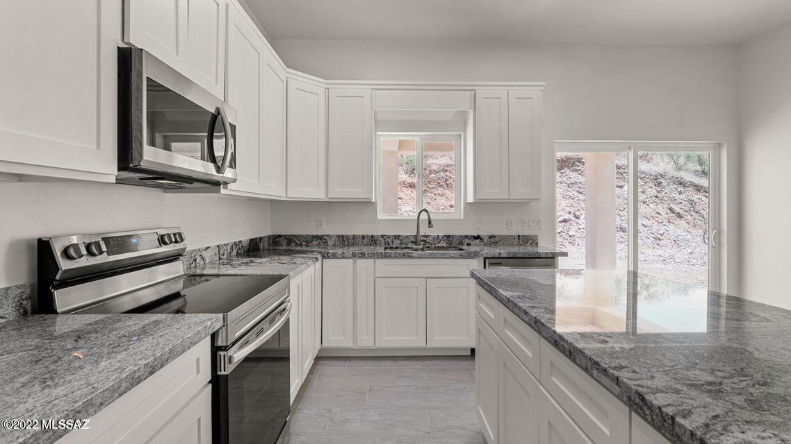 286 Guaymas Rio Rico, AZ 85648 - Photo 5 of 12 a kitchen with stainless steel appliances granite countertop a sink stove and microwave