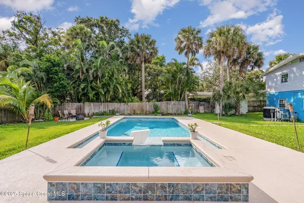 a view of swimming pool with a garden and trees