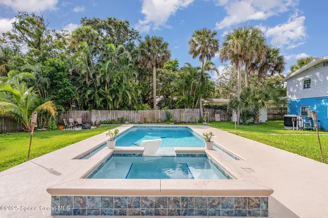 a view of swimming pool with a garden and trees
