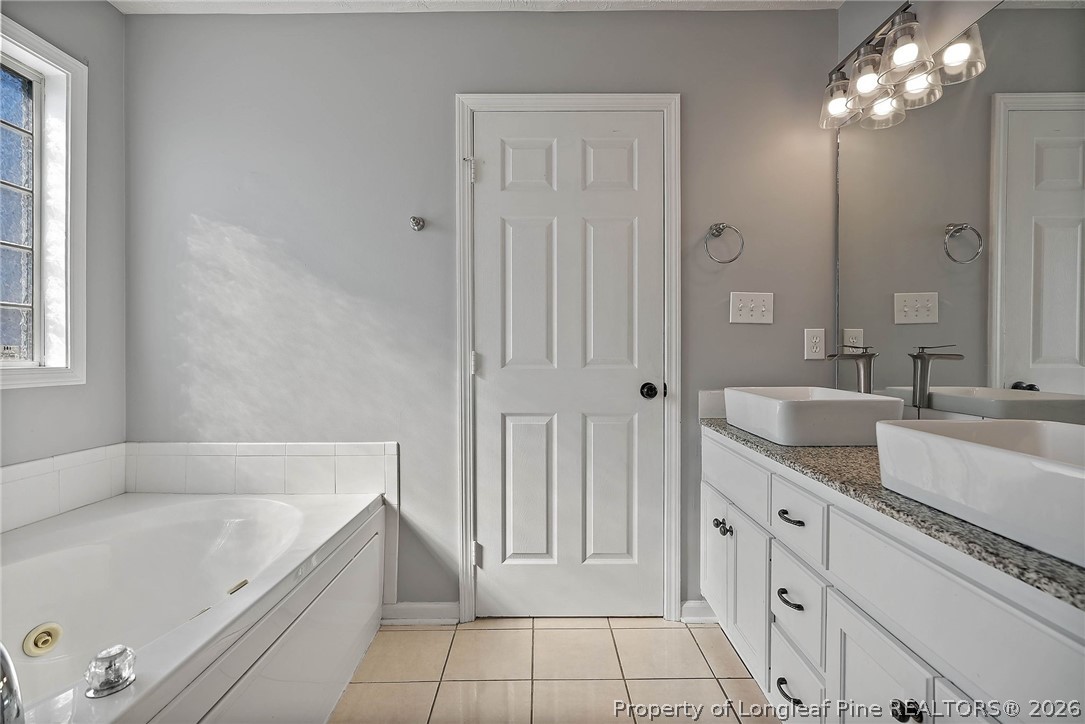 5353 Pringle Way Hope Mills, NC 28348 - Photo 16 of 29 a spacious bathroom with a tub double sink and mirror