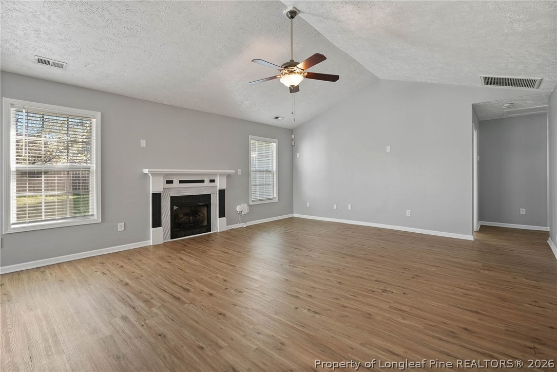 5353 Pringle Way Hope Mills, NC 28348 - Photo 4 of 29 a view of an empty room with wooden floor fireplace and a window