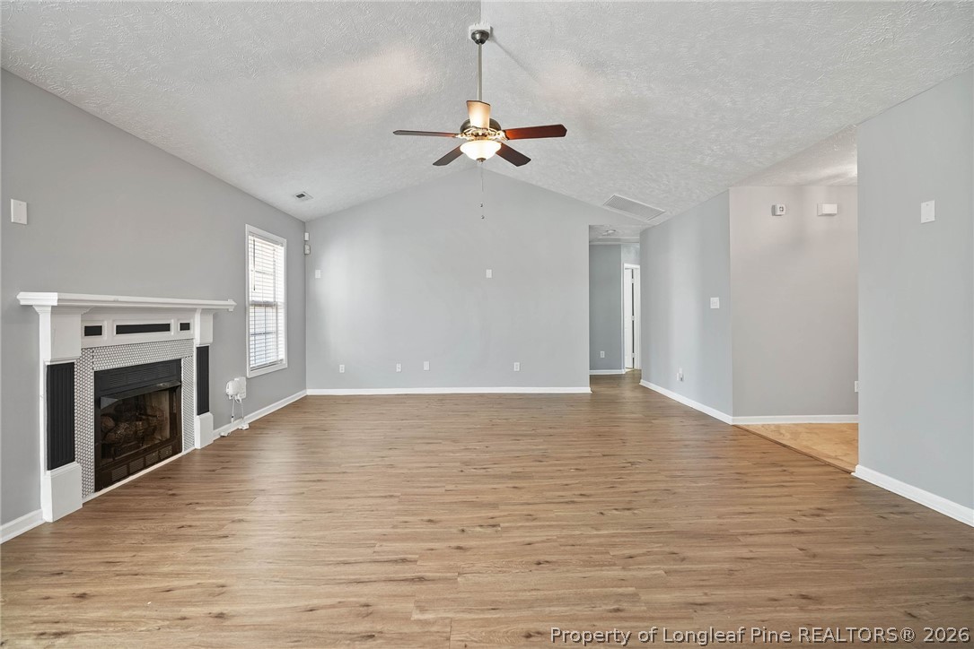 5353 Pringle Way Hope Mills, NC 28348 - Photo 5 of 29 an empty room with wooden floor fireplace and windows