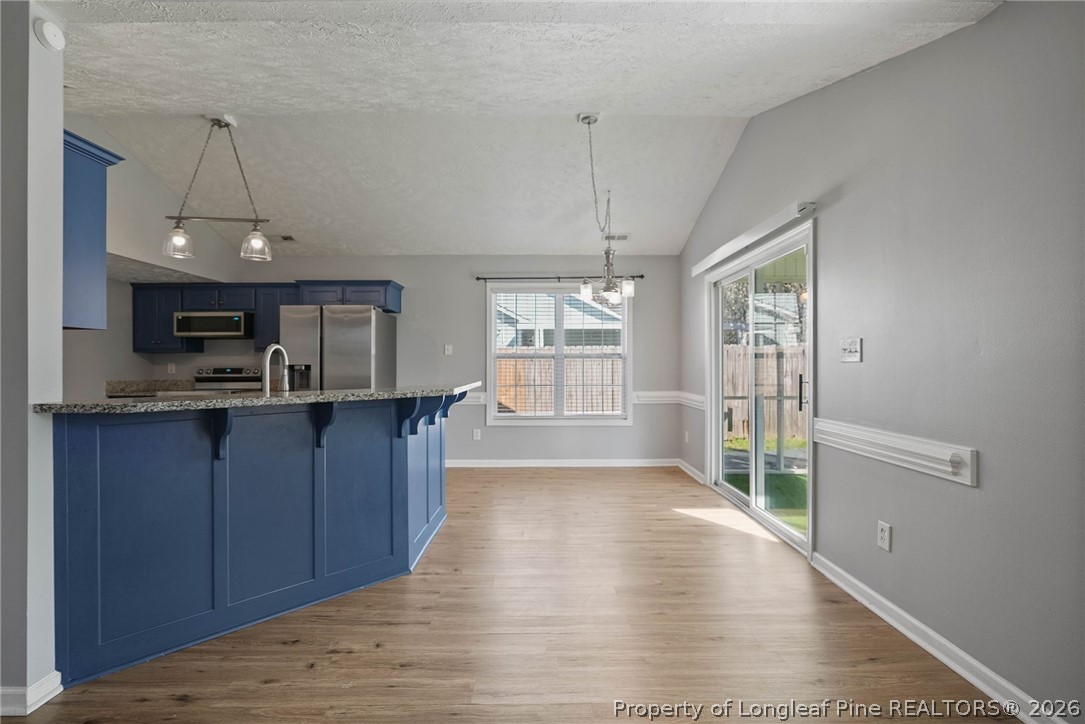 5353 Pringle Way Hope Mills, NC 28348 - Photo 7 of 29 a open kitchen with a sink a refrigerator and wooden cabinets