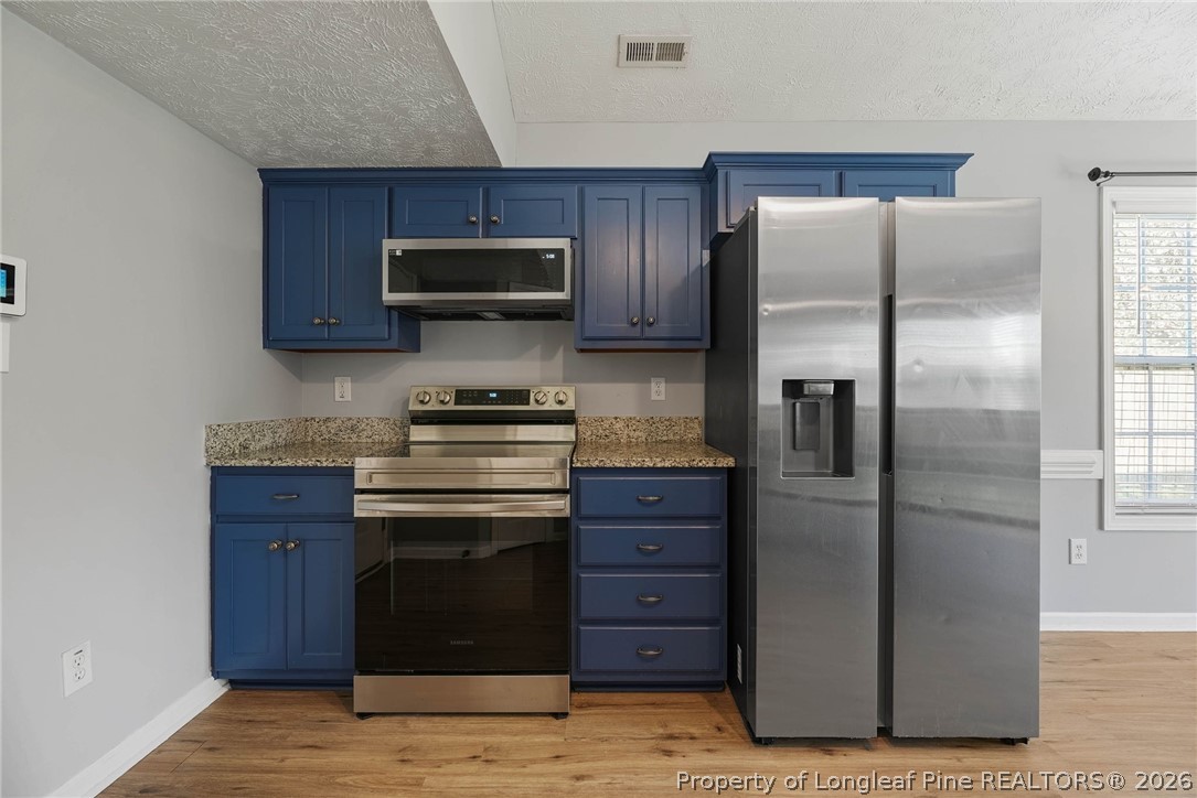 5353 Pringle Way Hope Mills, NC 28348 - Photo 8 of 29 a kitchen with stainless steel appliances granite countertop a refrigerator and a stove top oven