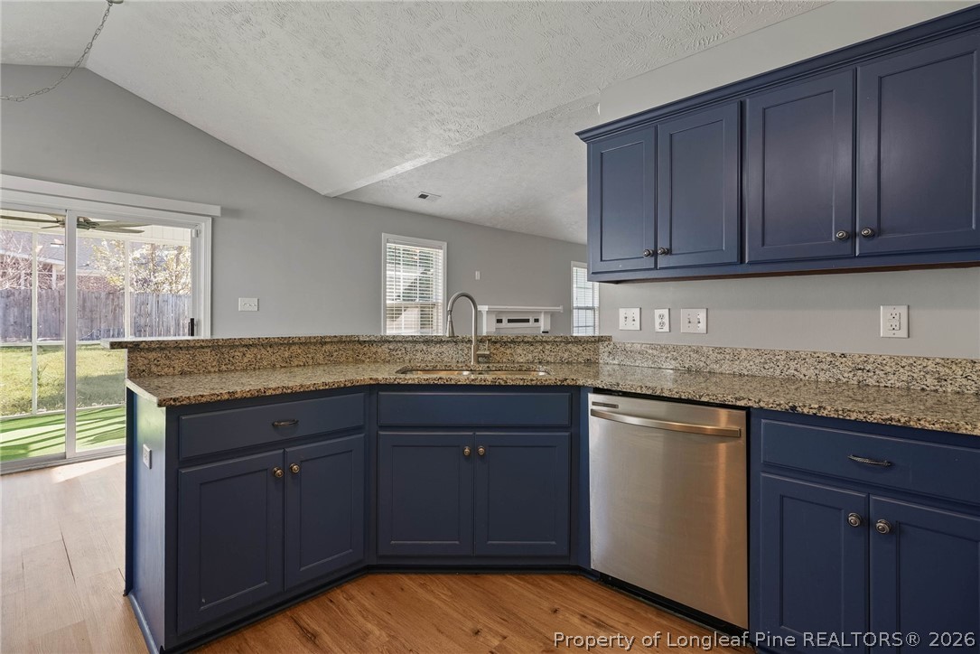 5353 Pringle Way Hope Mills, NC 28348 - Photo 10 of 29 a kitchen with granite countertop wooden cabinets and a counter top space