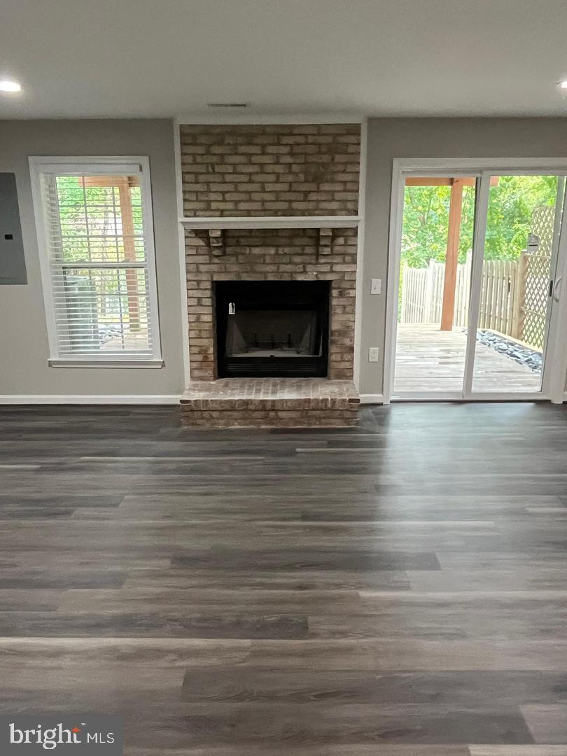 355 Crescendo Way Silver Spring, MD 20901 - Photo 15 of 23 an empty room with wooden floor fireplace and windows