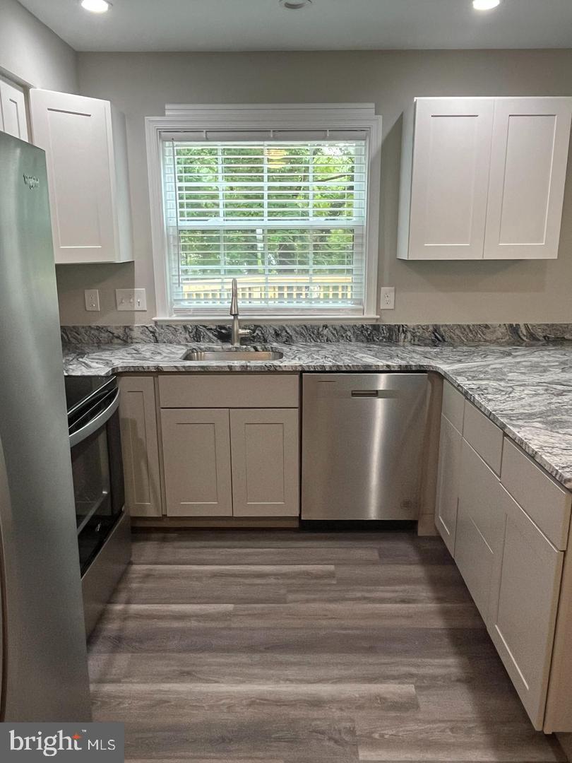 355 Crescendo Way Silver Spring, MD 20901 - Photo 20 of 23 a kitchen with stainless steel appliances granite countertop a stove a sink and a microwave