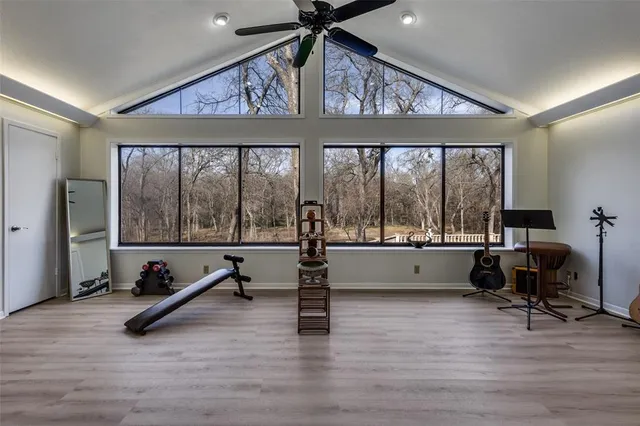 a view of an empty room with wooden floor and windows