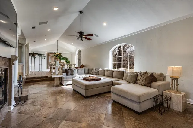 a living room with furniture a fireplace and a chandelier