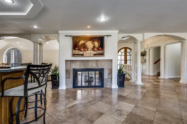 a living room with furniture a fireplace and a kitchen view