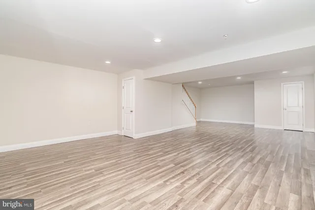 a view of empty room with wooden floor and windows
