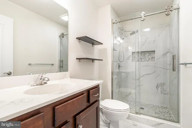a bathroom with a sink a toilet and shower