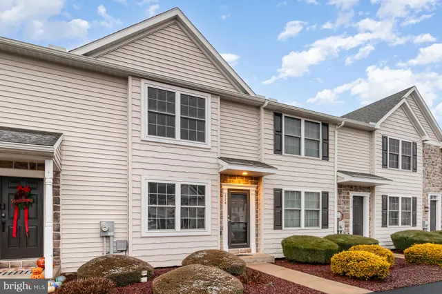 a view of a house with a yard and a fire pit