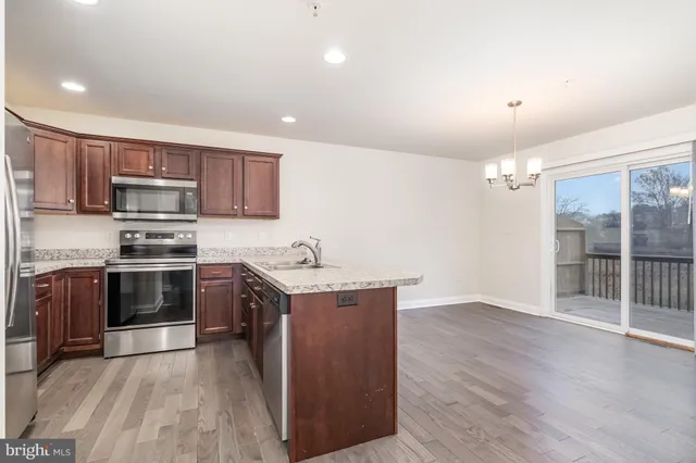 a kitchen with stainless steel appliances a stove a sink and a refrigerator