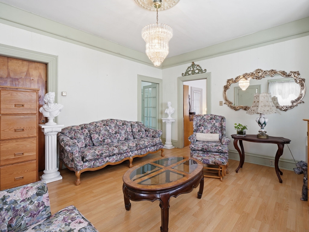 223 Stackpole Street Lowell, MA 01852 - Photo 3 of 42 a living room with furniture and a wooden floor