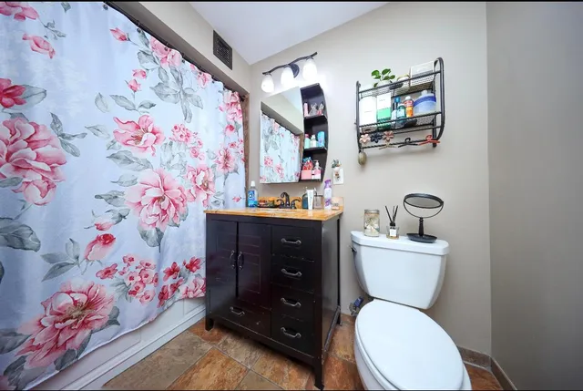 a bathroom with a toilet sink and mirror