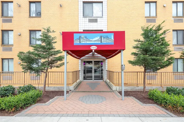 a view of a building with a small yard and wooden fence