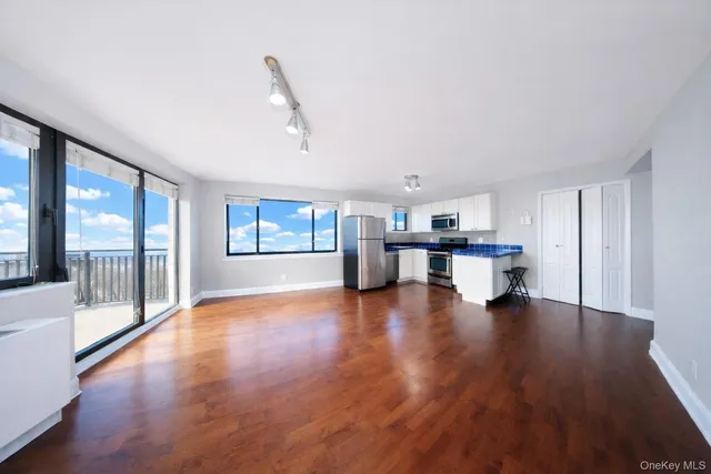 a view of empty room with wooden floor and floor to ceiling window