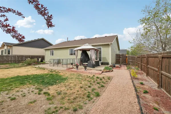 a view of a house with backyard sitting area and garden