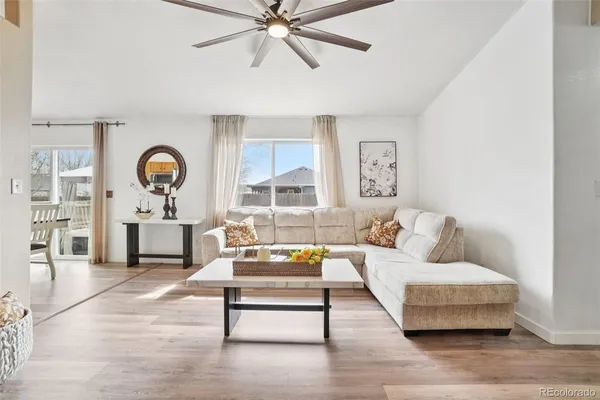 a living room with furniture and a wooden floor
