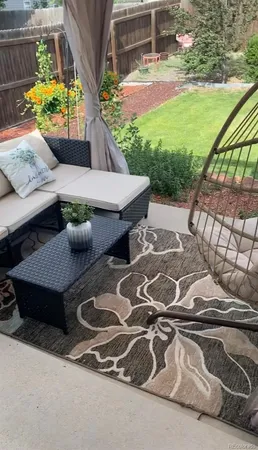 a view of a patio with table and chairs with wooden floor and fence