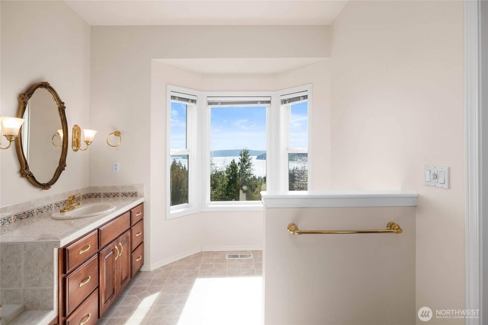 8661 Southridge Place Anacortes, WA 98221 - Photo 19 of 39 a bathroom with a sink a mirror a vanity and a window