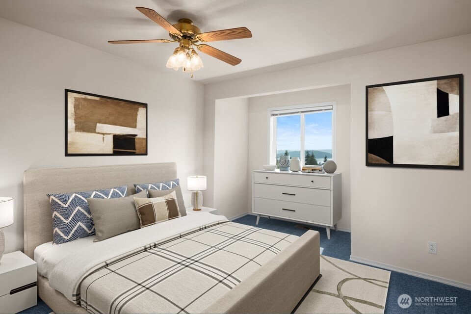 8661 Southridge Place Anacortes, WA 98221 - Photo 24 of 39 a bedroom with a bed and a chandelier