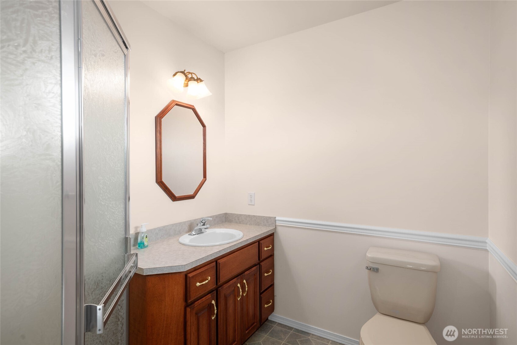 8661 Southridge Place Anacortes, WA 98221 - Photo 27 of 39 a bathroom with a granite countertop toilet sink and mirror