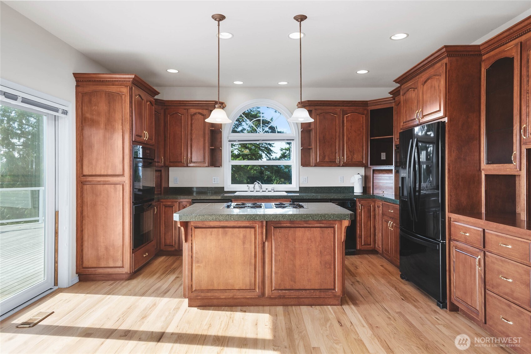 8661 Southridge Place Anacortes, WA 98221 - Photo 8 of 39 a kitchen with stainless steel appliances granite countertop a refrigerator a stove and a wooden floors