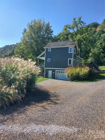 a view of a house with a wooden deck and a yard