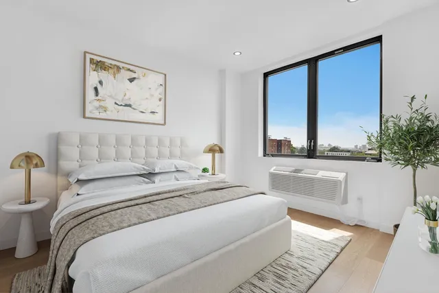 a bedroom with a large bed and a potted plant