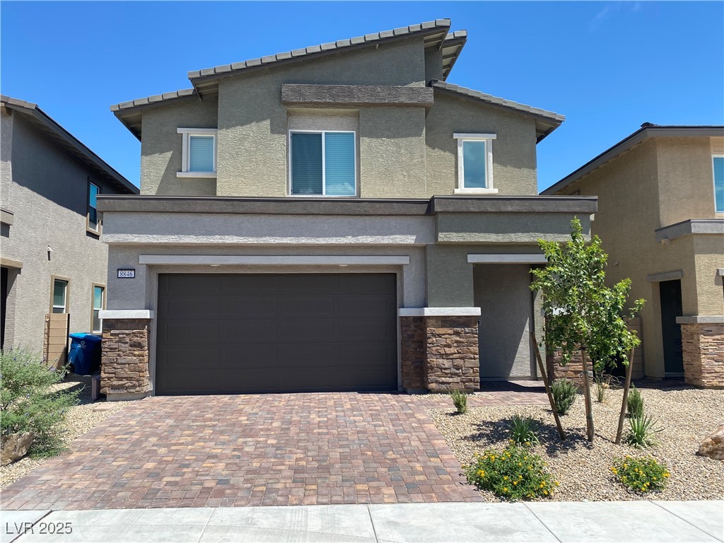 8846 Sasquatch Run Avenue Las Vegas, NV 89166 - Photo 1 of 21 View of front of property featuring stone siding, stucco siding, decorative driveway, and an attached garage