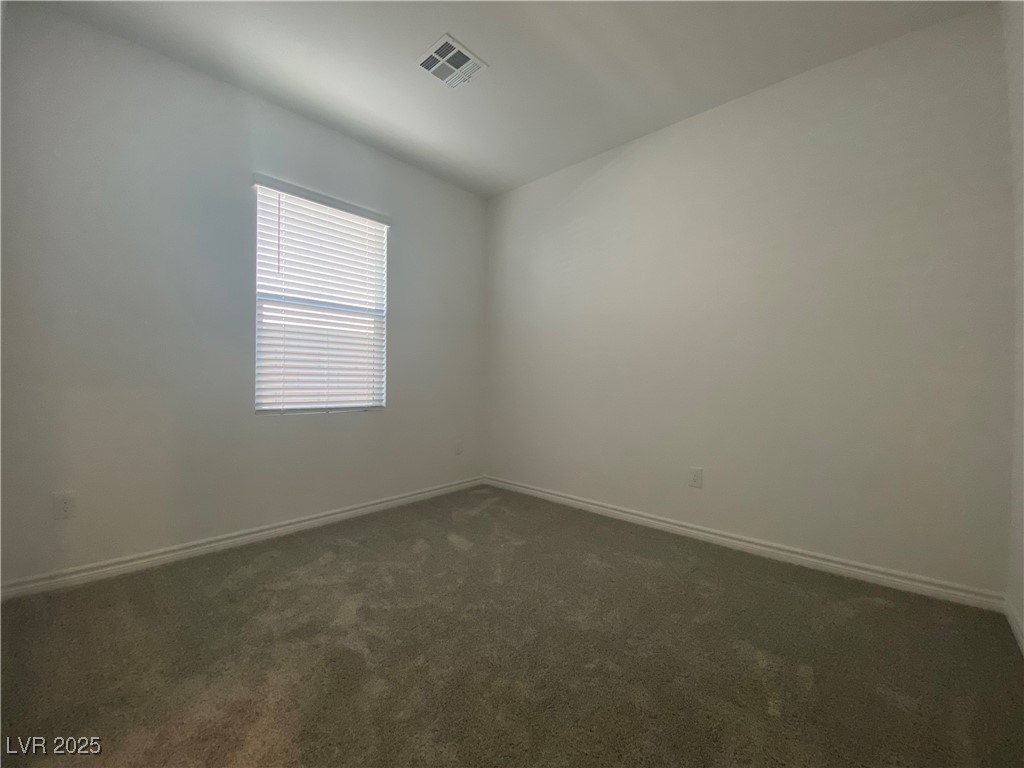 8846 Sasquatch Run Avenue Las Vegas, NV 89166 - Photo 11 of 21 Empty room with dark carpet and baseboards