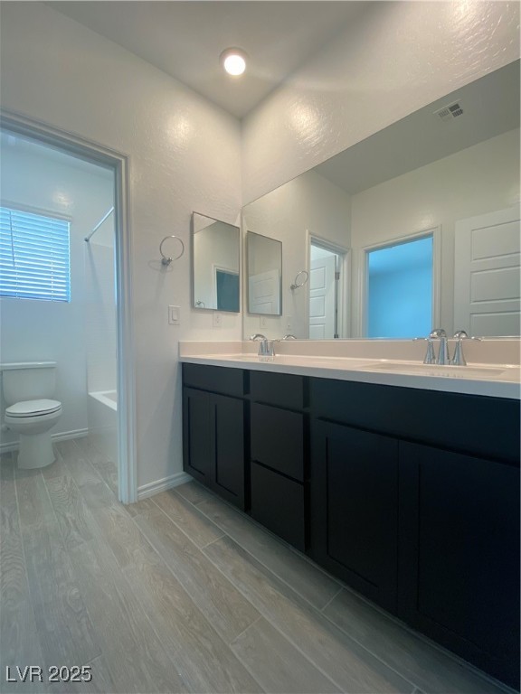 8846 Sasquatch Run Avenue Las Vegas, NV 89166 - Photo 17 of 21 Full bathroom featuring light wood-style floors, washtub / shower combination, and double vanity